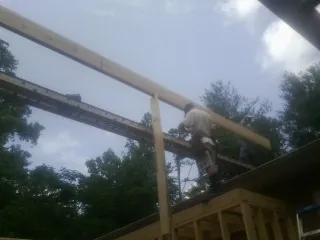 Carpenter setting a ridge beam over a new addition frame — Ice Dam Removal by Roofing Brothers in Rock Island