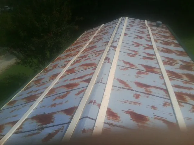 Rusted metal roof panels with new wood purlins before replacement — Storm Damage Roof Repair in Rock Island by Roofing Brothers