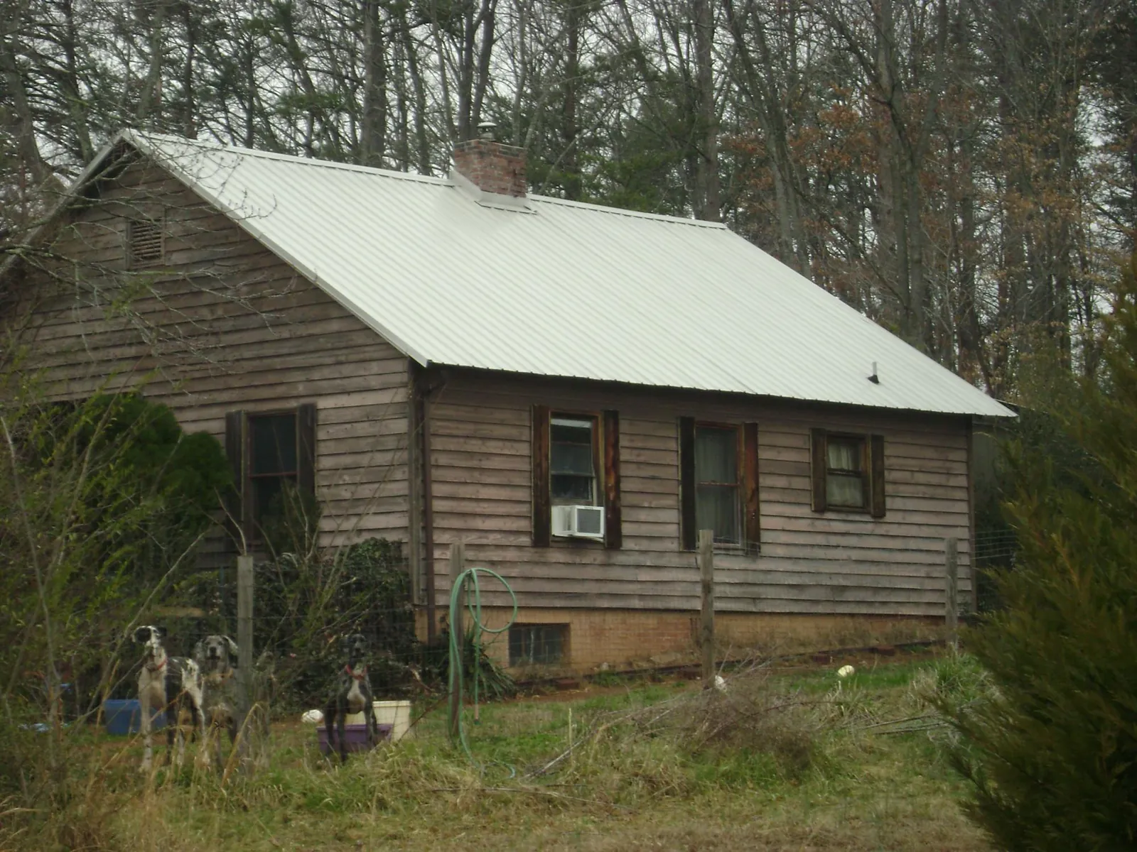 White metal roof on an old wood sided farmhouse, from a Metal Roof Installation job in Rock Island